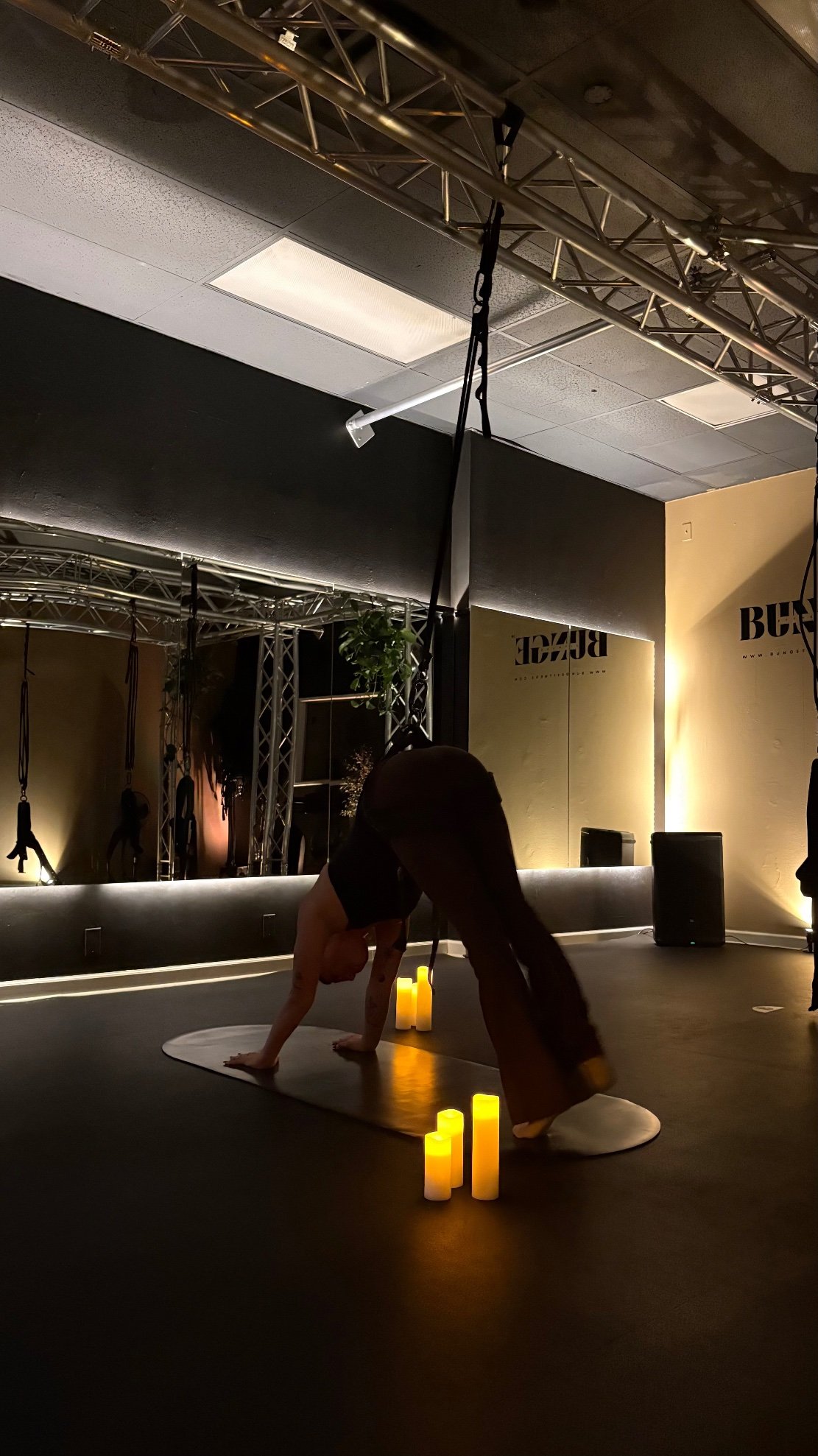 A stretch silhouette in low candlelight at BUNGE Fitness in Huntington Beach